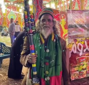 رجل بملابس غريبة وممسك بأشياء وصفت بالمثيرة للجدل